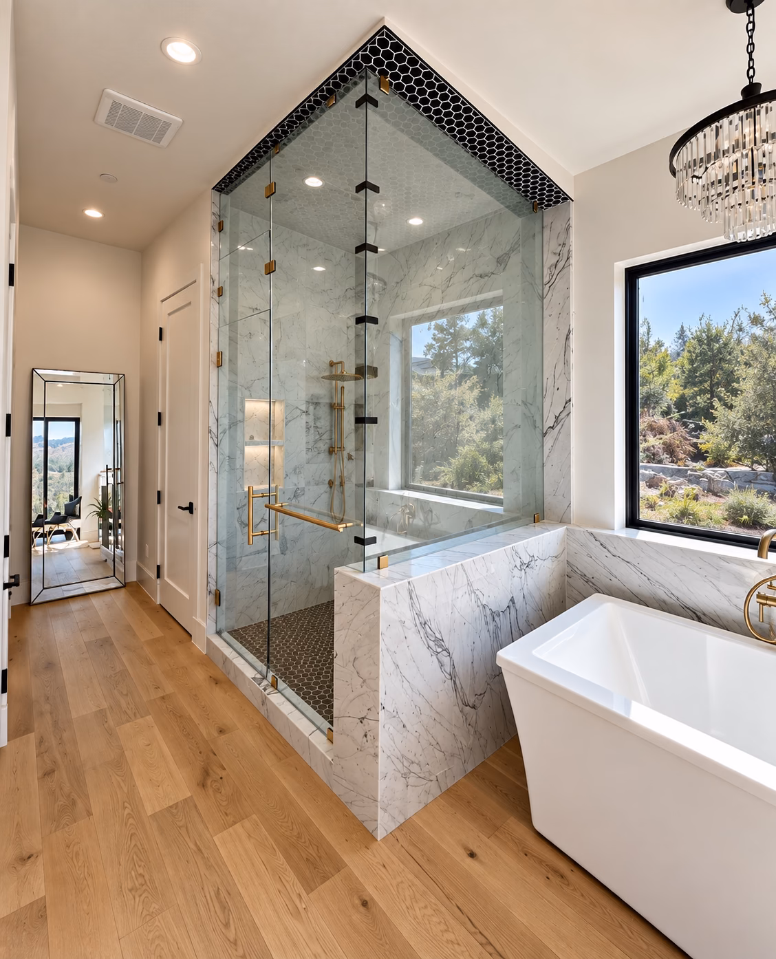 Primary bath with a glass shower under a black hex crown and a freestanding tub on oak